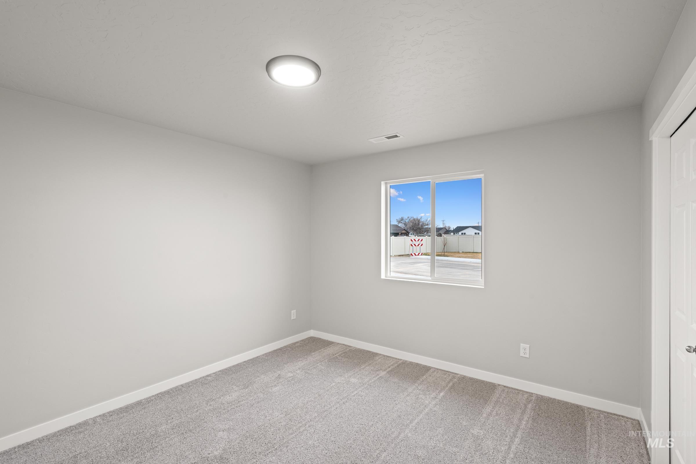 924 Northeast Trailridge Court Mountain Home, ID 83647 - Photo 13 of 21 Unfurnished bedroom with light colored carpet and a closet