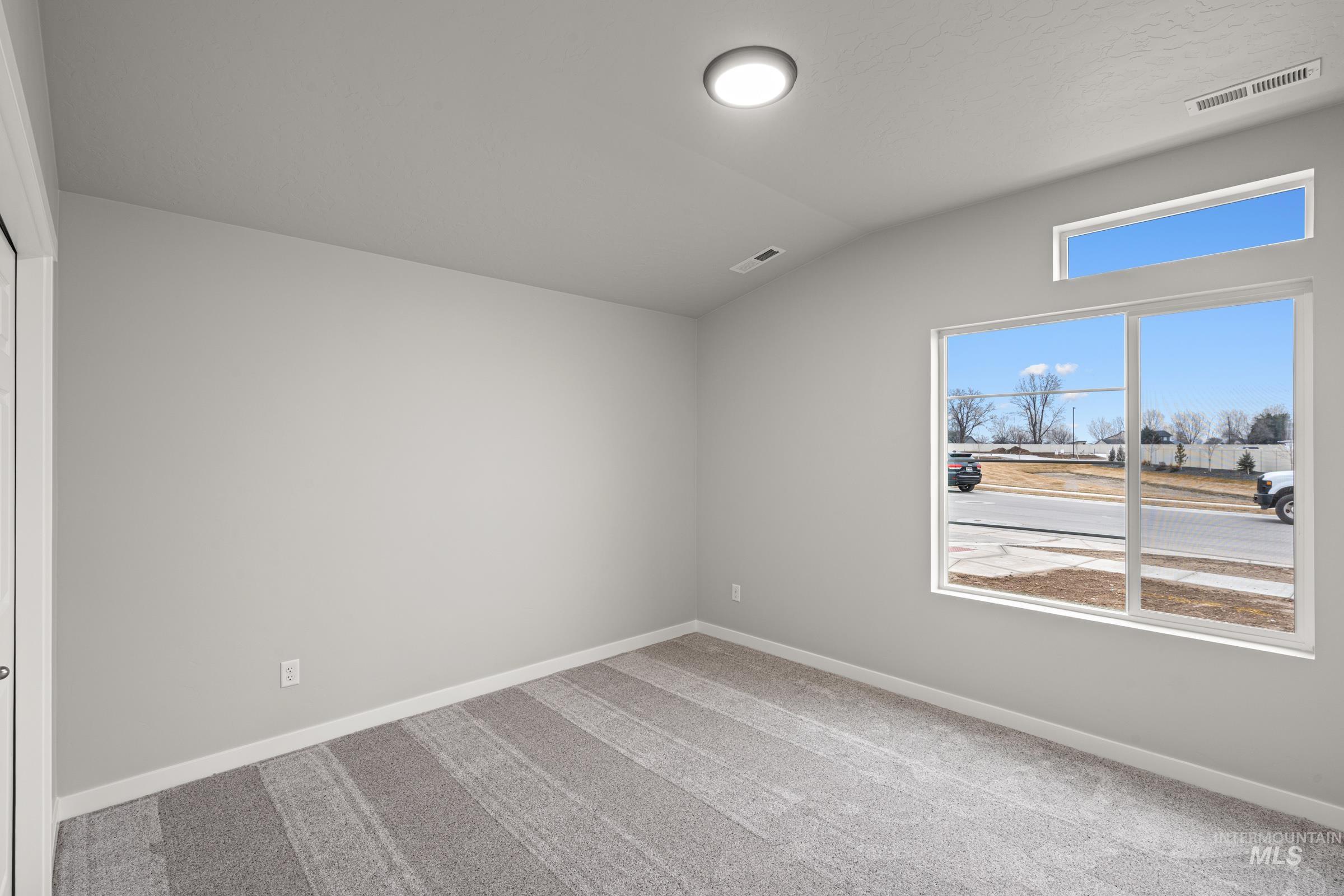 924 Northeast Trailridge Court Mountain Home, ID 83647 - Photo 14 of 21 Spare room with vaulted ceiling and light carpet