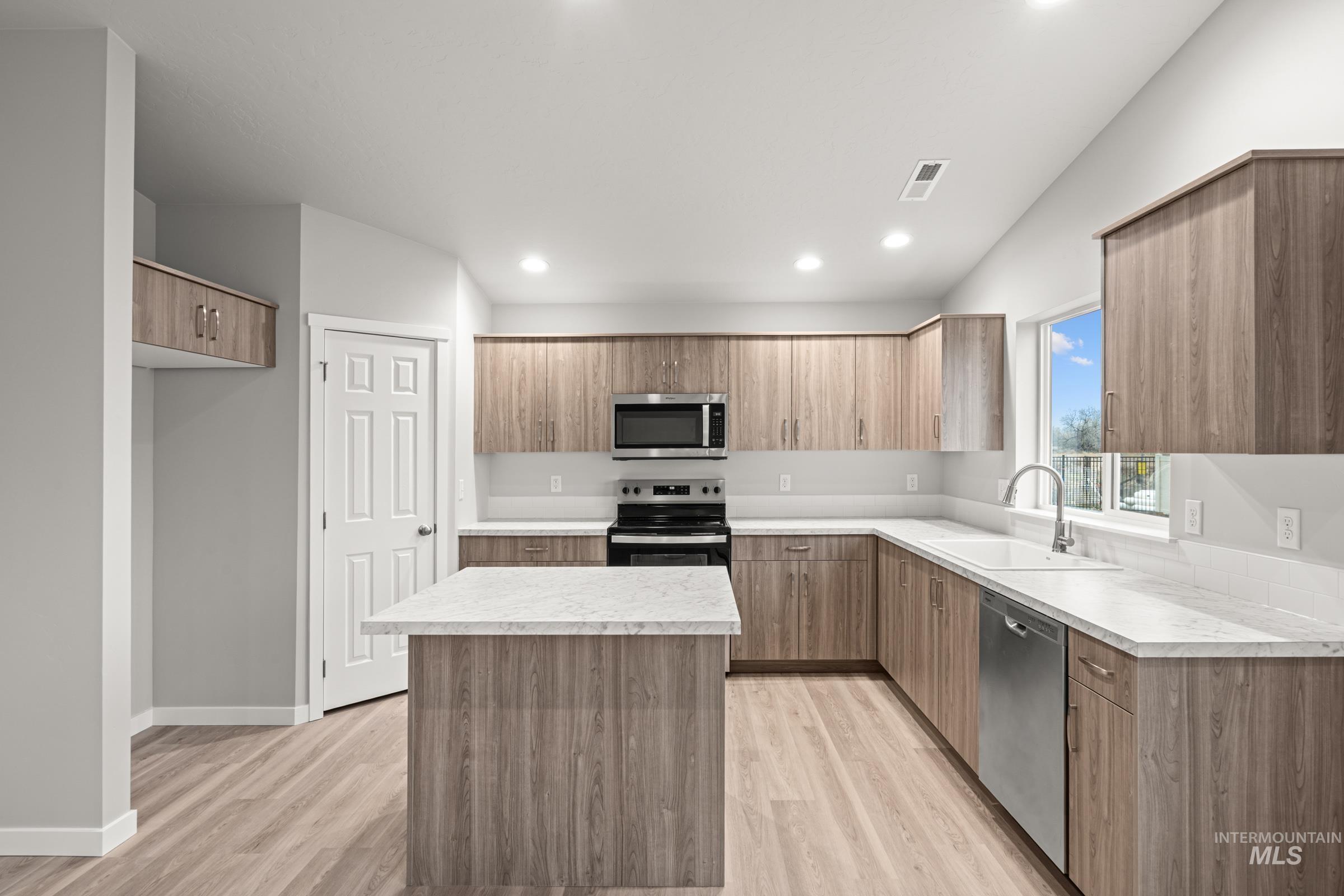 924 Northeast Trailridge Court Mountain Home, ID 83647 - Photo 3 of 21 Kitchen with stainless steel appliances, a center island, light countertops, modern cabinets, and recessed lighting