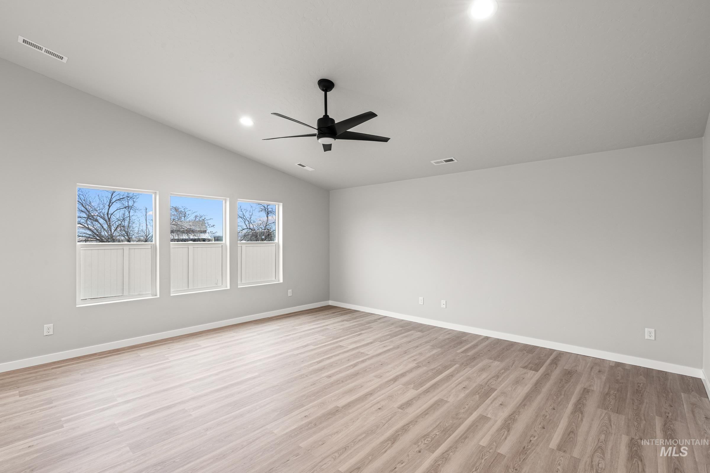 924 Northeast Trailridge Court Mountain Home, ID 83647 - Photo 7 of 21 Empty room with a ceiling fan, light wood finished floors, recessed lighting, and vaulted ceiling