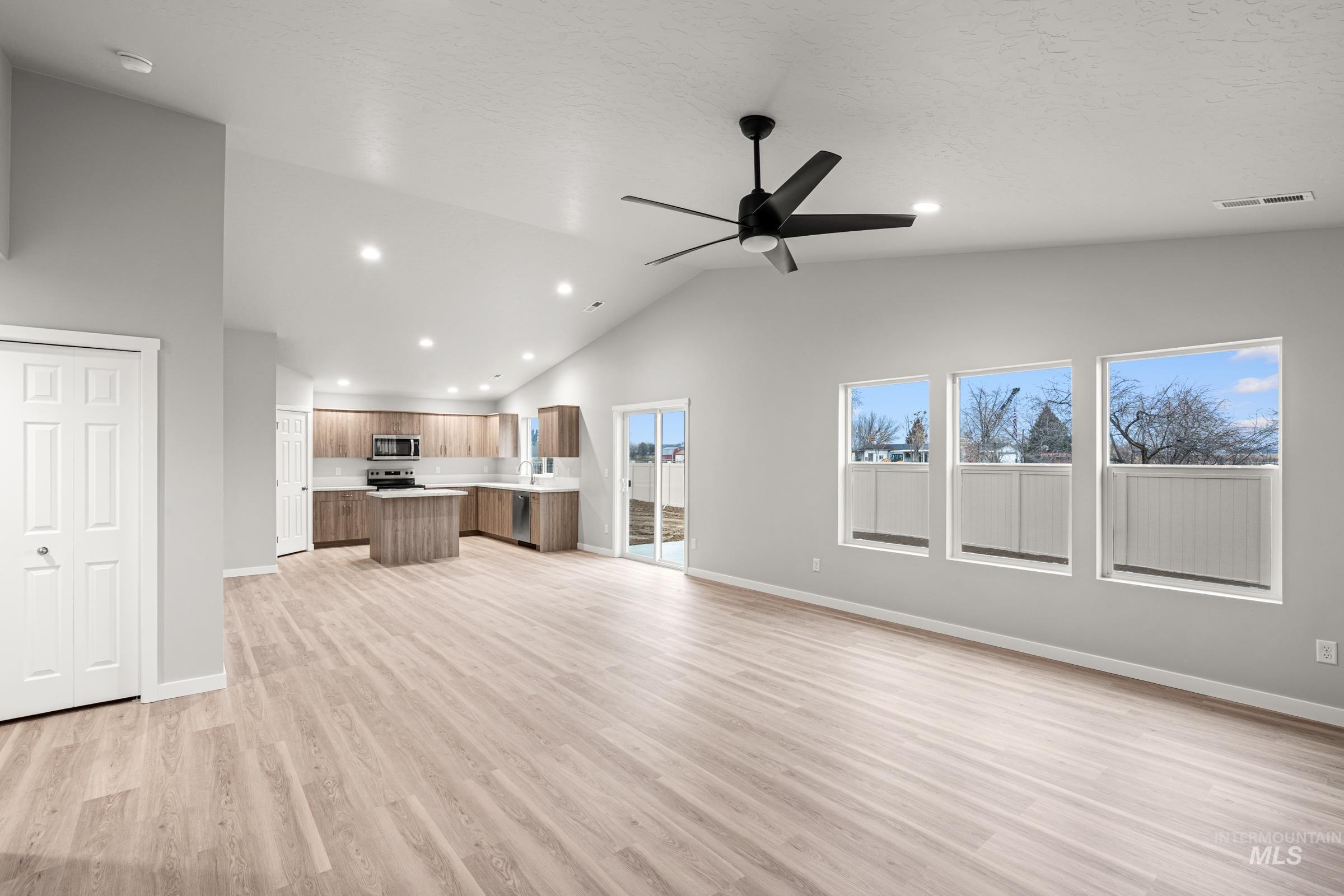 924 Northeast Trailridge Court Mountain Home, ID 83647 - Photo 9 of 21 Unfurnished living room featuring light wood finished floors, a ceiling fan, vaulted ceiling, and recessed lighting