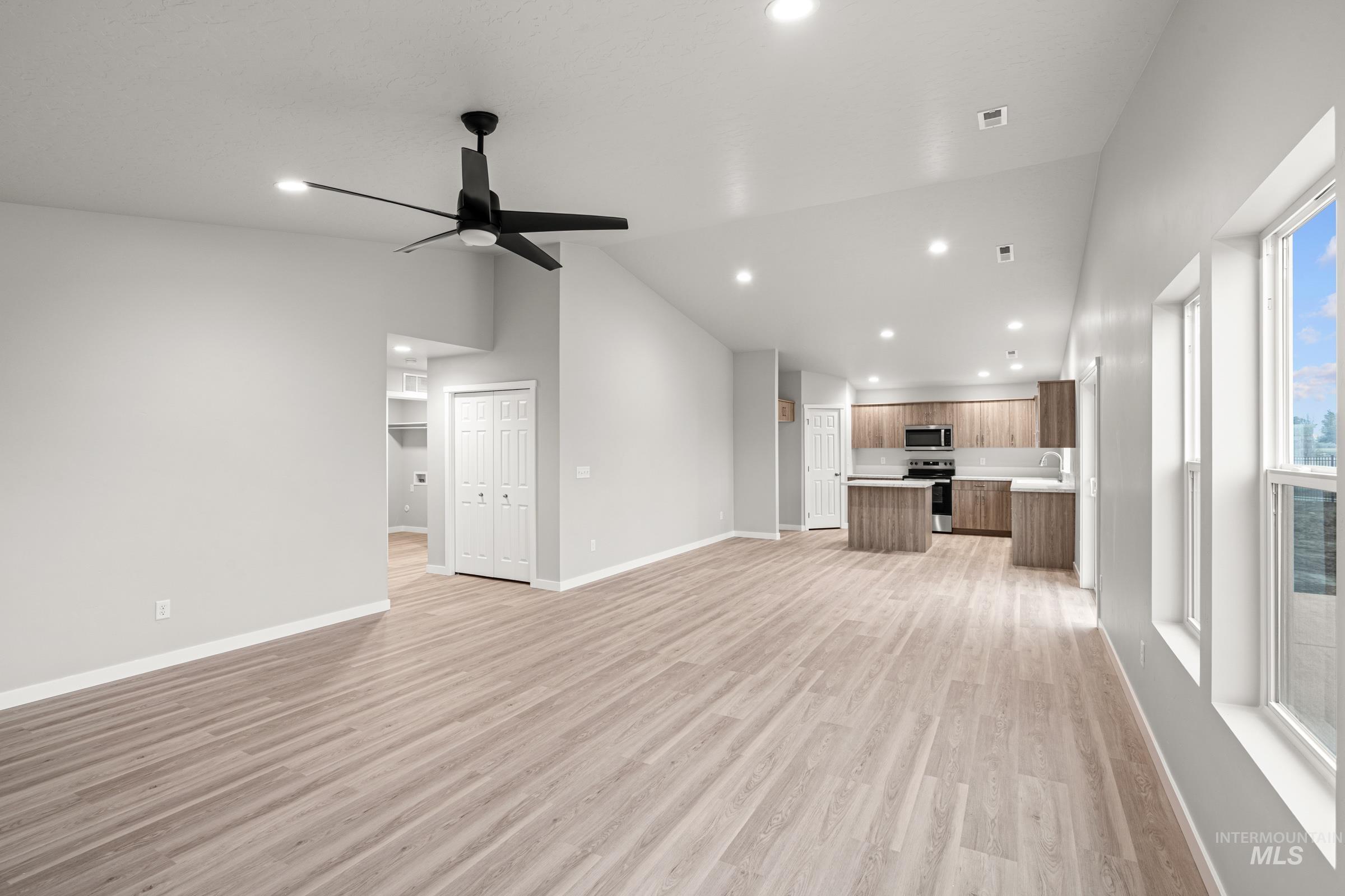 924 Northeast Trailridge Court Mountain Home, ID 83647 - Photo 10 of 21 Unfurnished living room with vaulted ceiling, light wood finished floors, ceiling fan, and recessed lighting