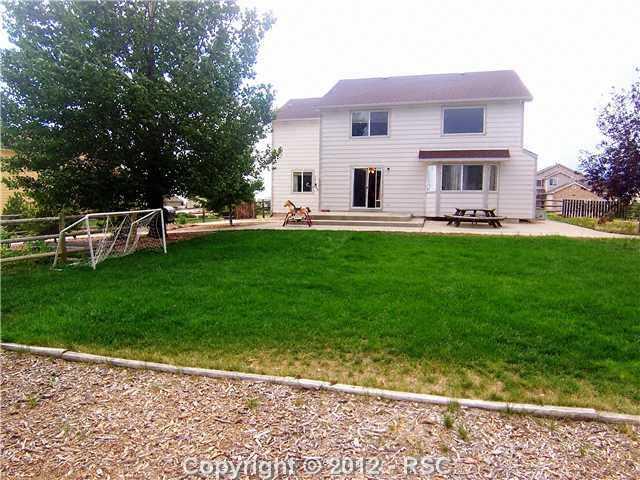 8563 Del Rio Road Peyton, CO 80831 - Photo 13 of 16 Huge Grassy Backyard with Maturing Shade Trees and Large Patio