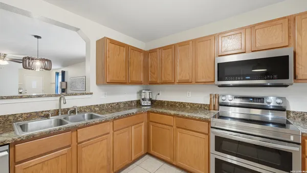 a kitchen with stainless steel appliances granite countertop a sink stove and microwave