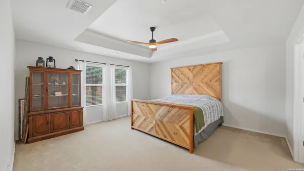 a spacious bedroom with a bed and a cabinets
