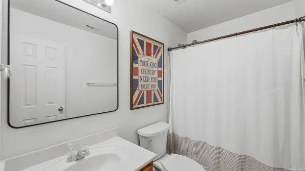a bathroom with a sink a toilet and shower curtain