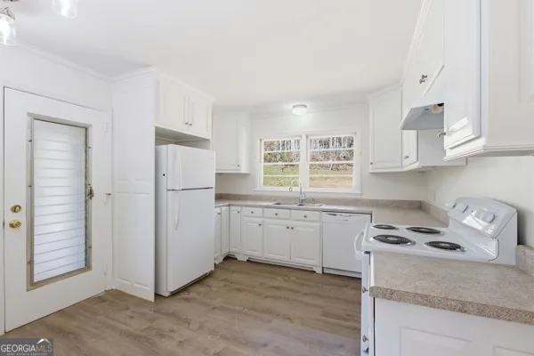 a kitchen with cabinets stove and sink