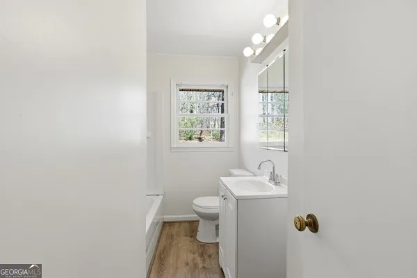 a bathroom with a toilet sink and mirror