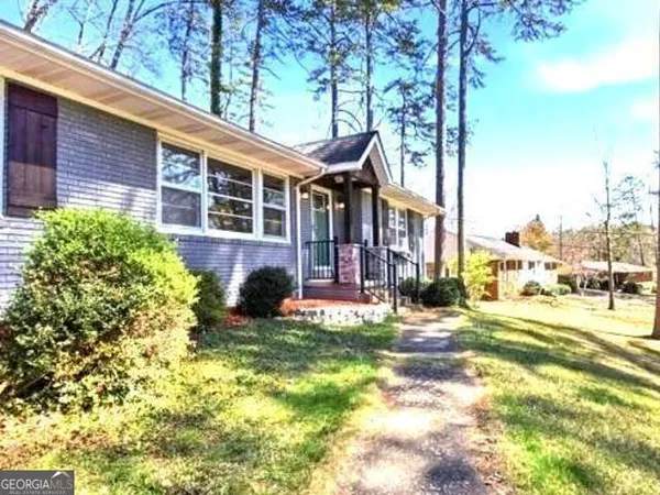 a front view of a house with a yard covered with snow and trees