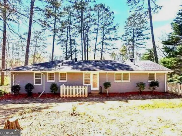 a view of a brick house with a yard in front of it