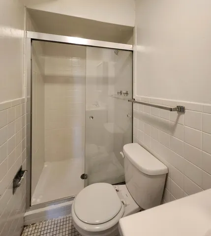 a white toilet sitting next to a bathroom