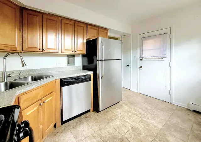 a kitchen with stainless steel appliances granite countertop a refrigerator and a sink