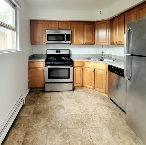a kitchen with kitchen island granite countertop a stove top oven microwave and cabinets