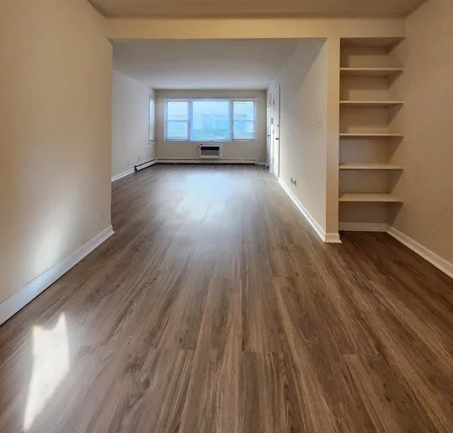 a view of a room with wooden floors and window