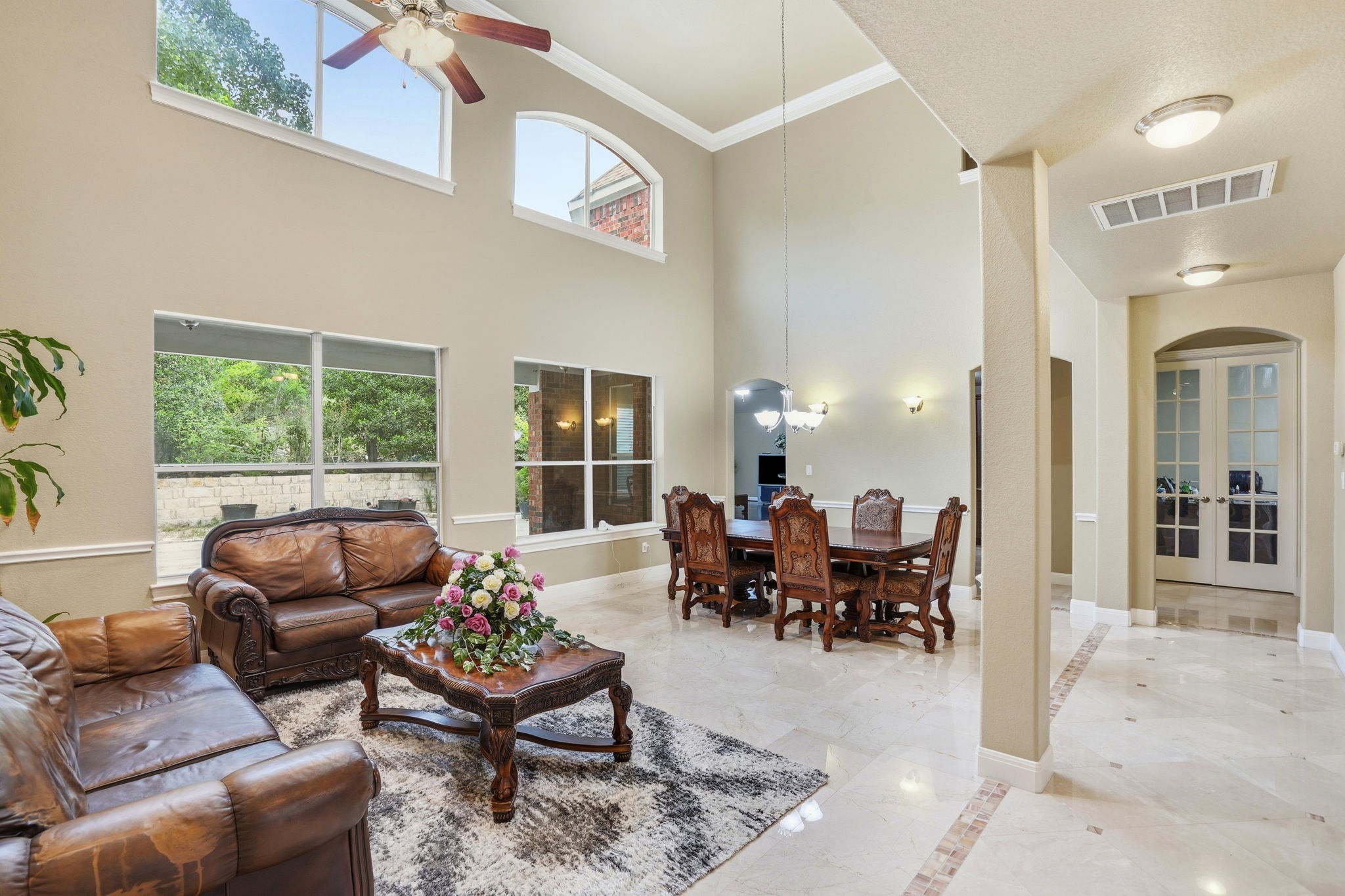 222 Vailco Lane Austin, TX 78738 - Photo 8 of 39 Two-story living area with high ceilings, multiple windows, and a ceiling fan