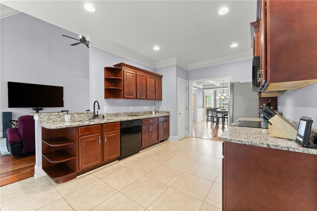 6643 Windvane Point Clermont, GA 30527 - Photo 19 of 88 a large kitchen with stainless steel appliances granite countertop a sink counter space and a stove top oven