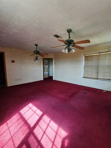 a view of a room with window and a ceiling fan