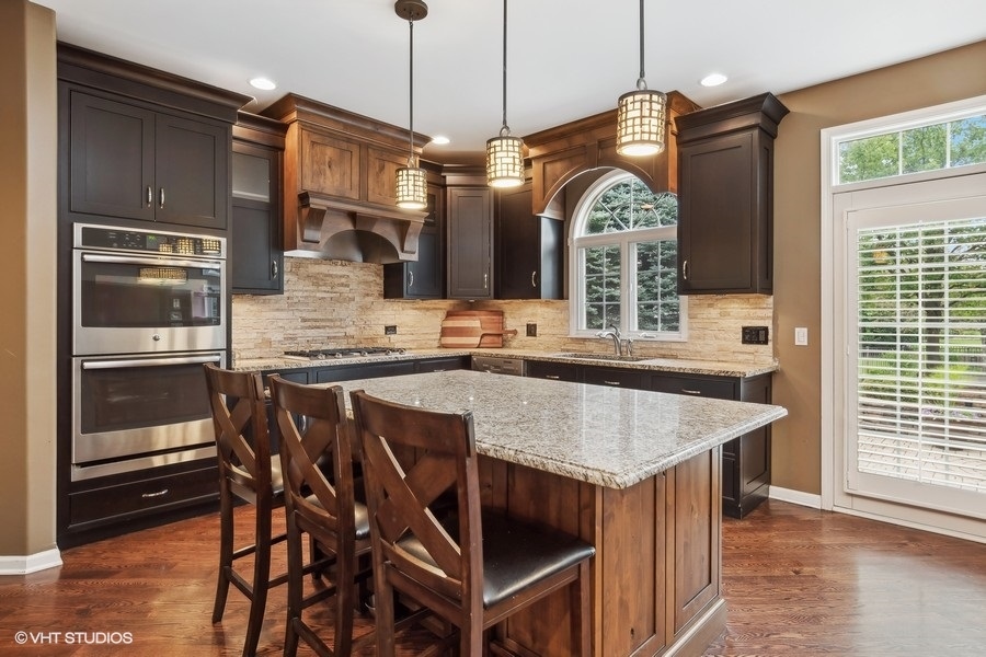 3179 Kingbird Lane Naperville, IL 60564 - Photo 18 of 52 a kitchen with stainless steel appliances granite countertop a kitchen island a stove a table and chairs