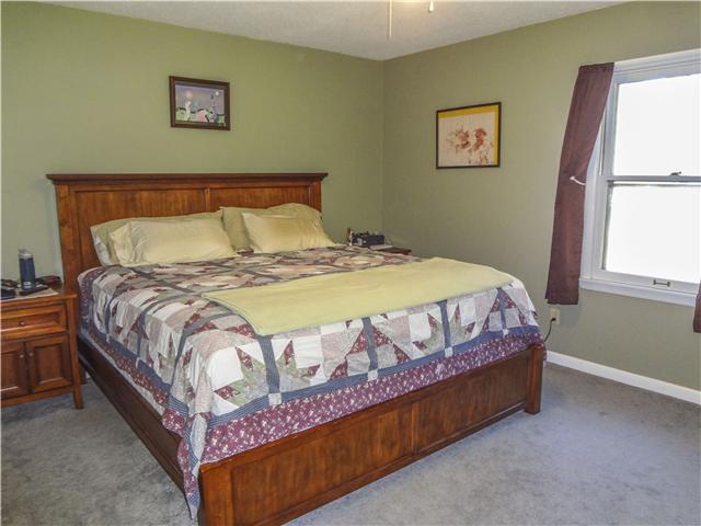 1186 Pleasant Ridge Road Goodspring, TN 38460 - Photo 18 of 20 a bed sitting in a bedroom next to a window
