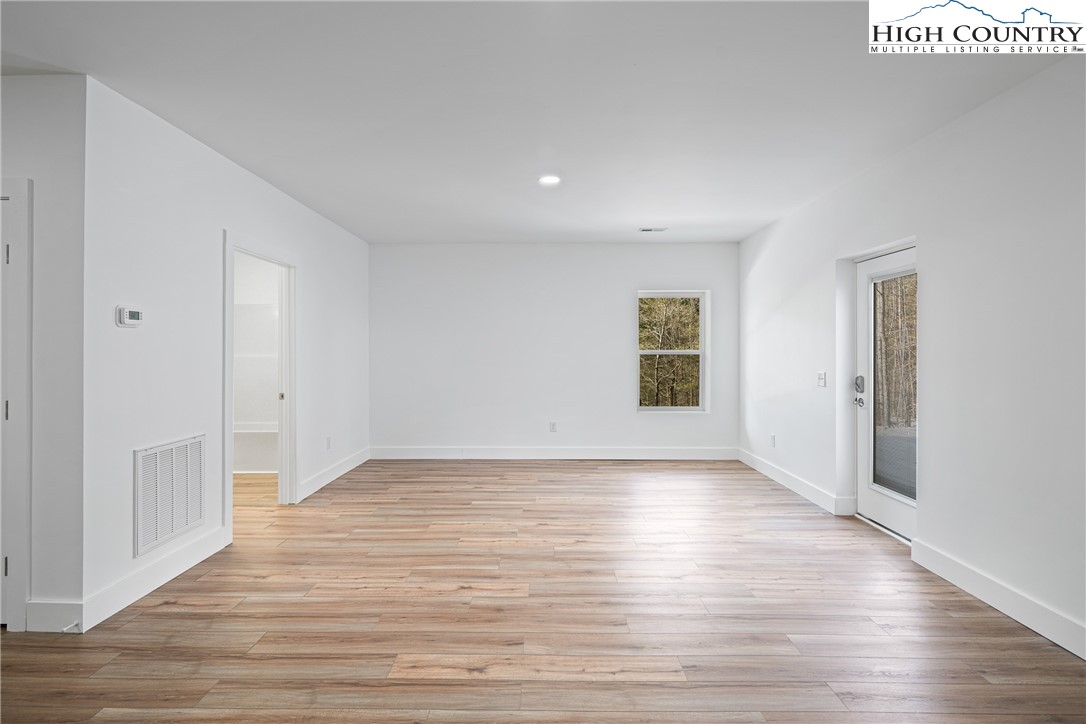 114 Woodpecker Road Purlear, NC 28665 - Photo 25 of 47 a view of an empty room with wooden floor and a window