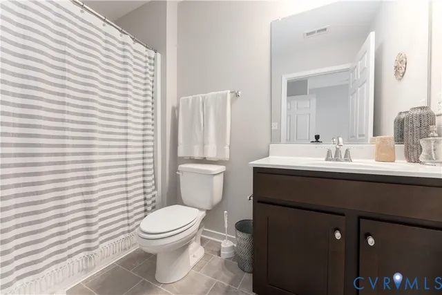 a bathroom with a sink a toilet and shower curtain
