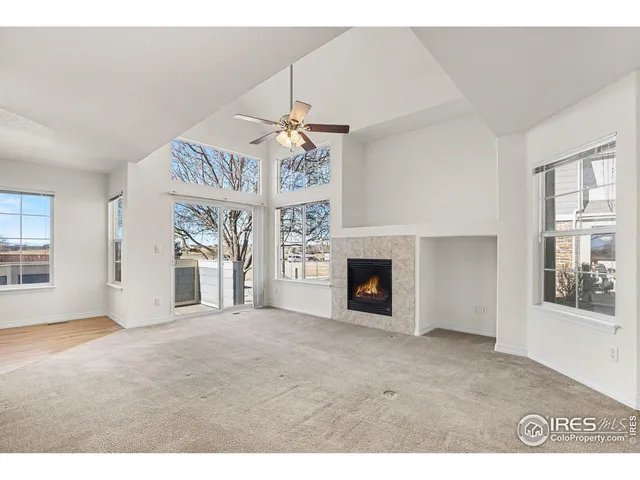 a view of an empty room with a fireplace and a window