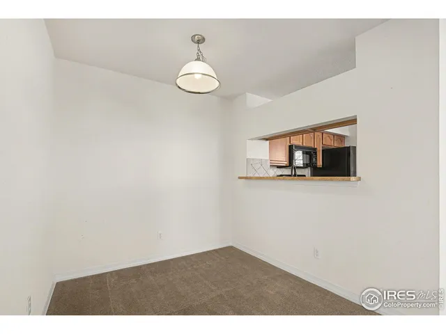 a view of a room with wooden floor and mirror