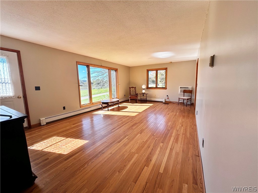 3564 Roszyk Hill Road Machias, NY 14101 - Photo 3 of 20 Polished hardwood flooring spans a bright room fea
