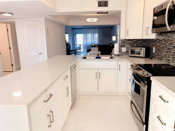 a kitchen with cabinets appliances a sink and a window