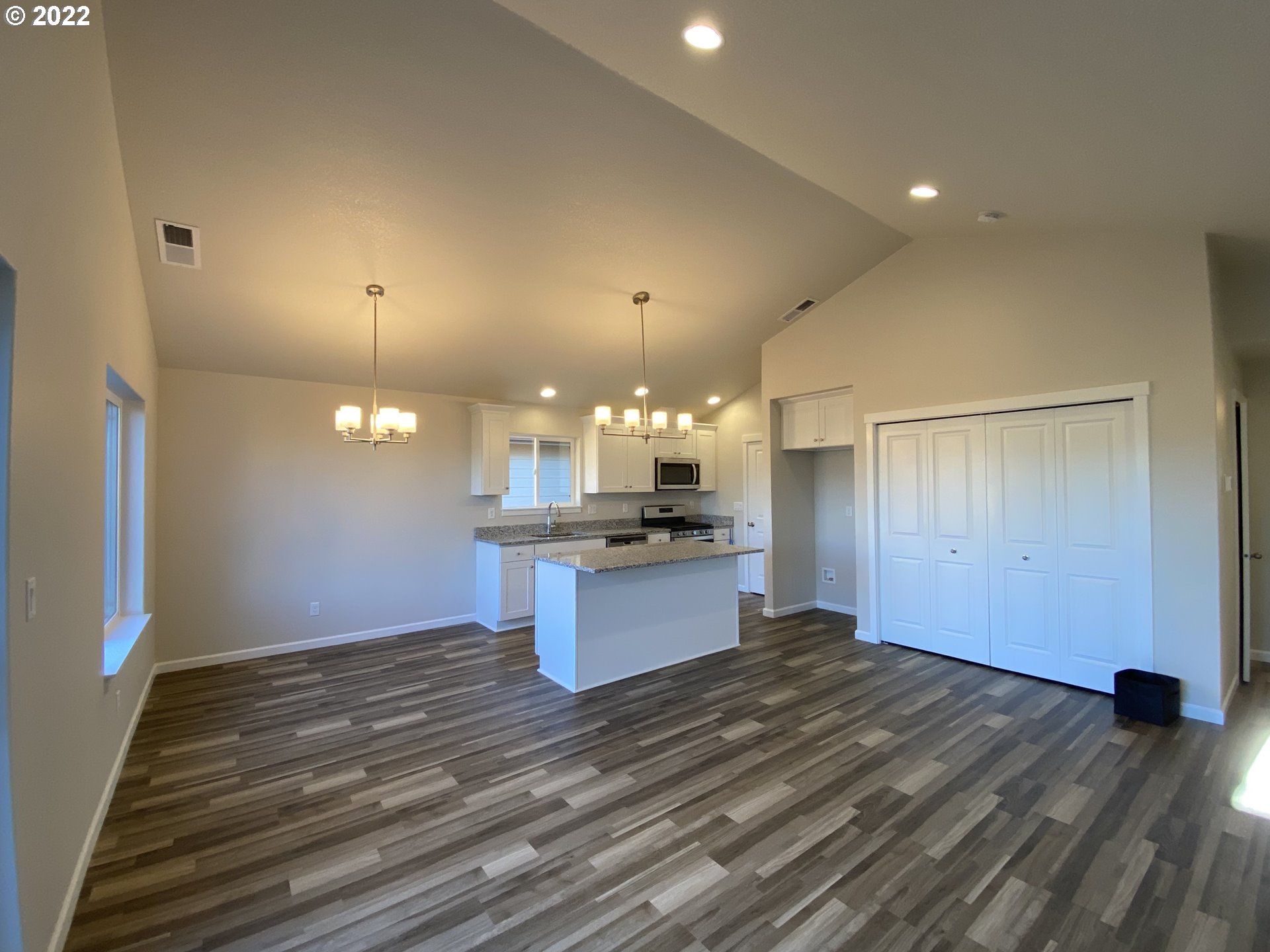413 Southeast Ray Street, Unit 39 Dallas, OR 97338 - Photo 6 of 15 a kitchen with a sink and chandelier