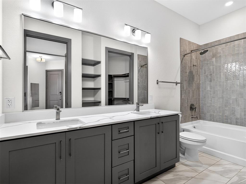 2700 Old Denton Road, Unit 3370 Carrollton, TX 75007 - Photo 17 of 35 a bathroom with a granite countertop sink toilet mirror and bathtub