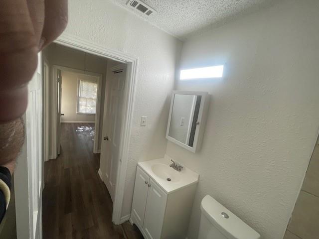 7428 Gaston Avenue Fort Worth, TX 76116 - Photo 14 of 17 a bathroom with a sink and mirror with toilet