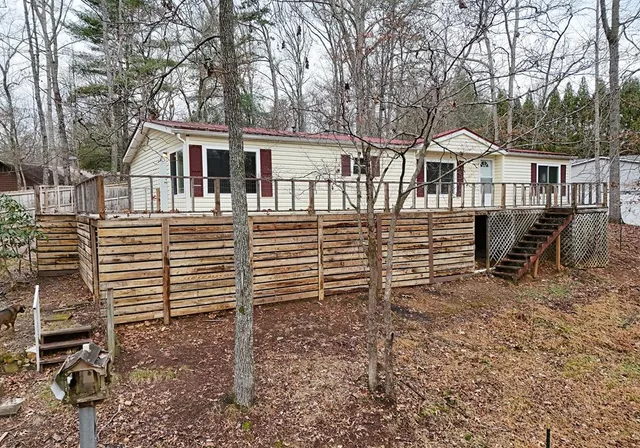 a view of a house with a yard and wooden fence