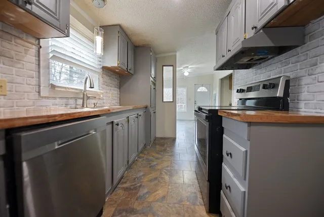 a kitchen with stainless steel appliances granite countertop a sink a stove and a refrigerator