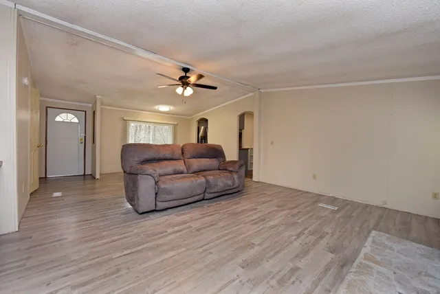 a living room with furniture and a ceiling fan