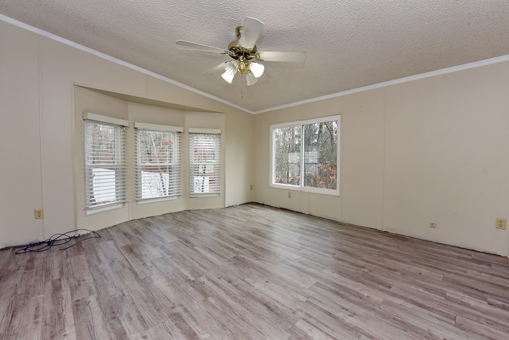 85 Truelove Road Blairsville, GA 30512 - Photo 9 of 35 a view of an empty room with wooden floor and a window