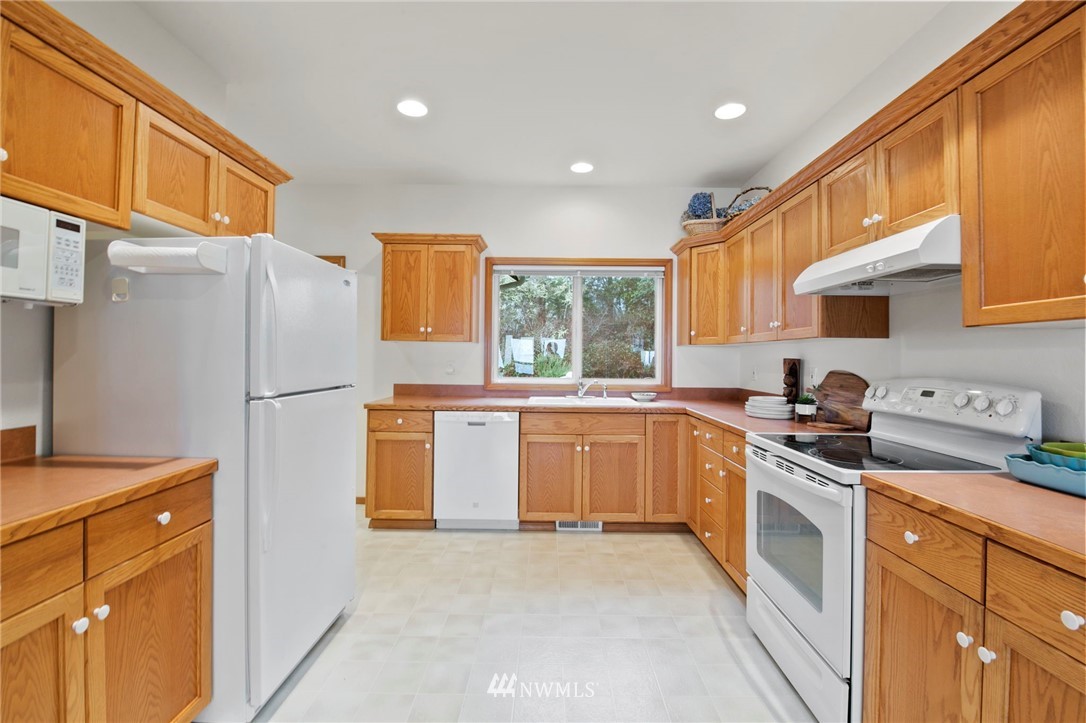 200 East Sund Road Grapeview, WA 98546 - Photo 16 of 40 a kitchen with stainless steel appliances granite countertop a refrigerator sink and stove
