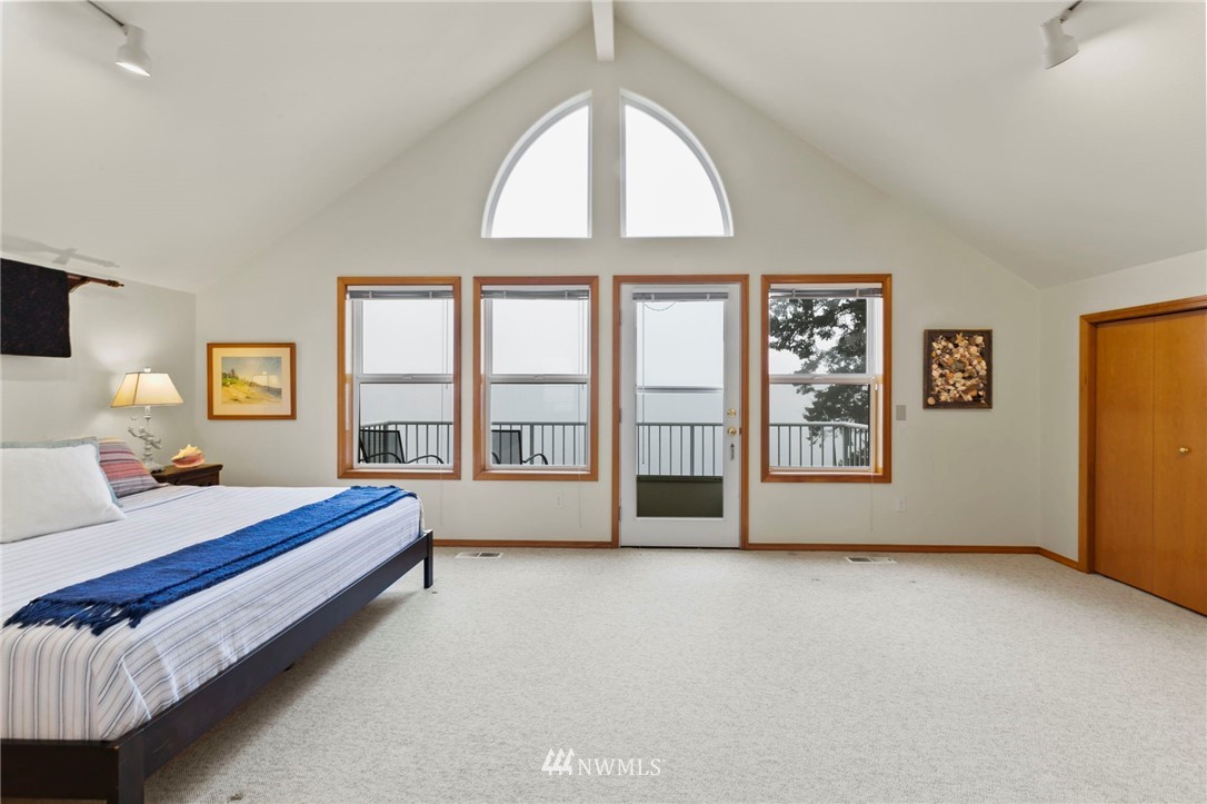 200 East Sund Road Grapeview, WA 98546 - Photo 23 of 40 a spacious bedroom with a bed and a large window