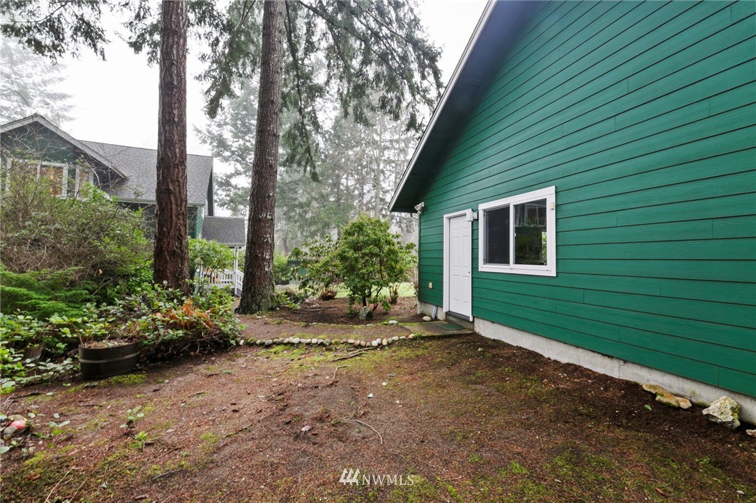 200 East Sund Road Grapeview, WA 98546 - Photo 33 of 40 a view of a backyard with plants and large trees
