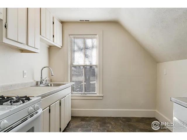 a kitchen with stainless steel appliances a sink a stove and white cabinets