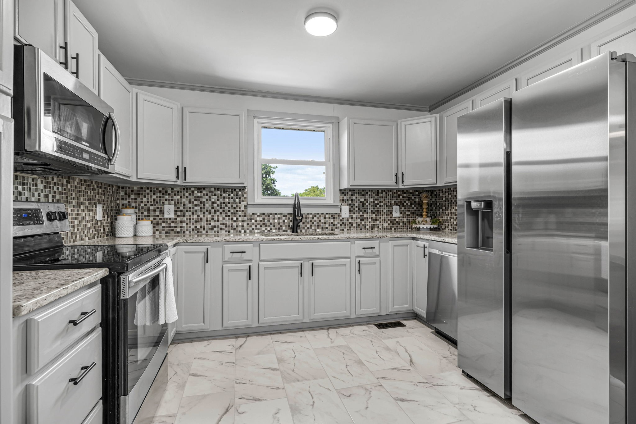 1177 Hamilton Chambers Road Lebanon, TN 37087 - Photo 13 of 42 a kitchen with granite countertop a sink stainless steel appliances and white cabinets