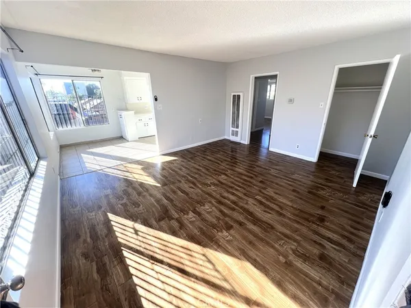 a view of empty room with wooden floor