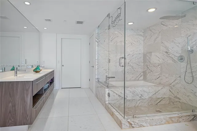 a bathroom with a double vanity sink toilet and tub