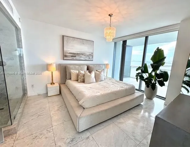 a bedroom with a large bed and a chandelier