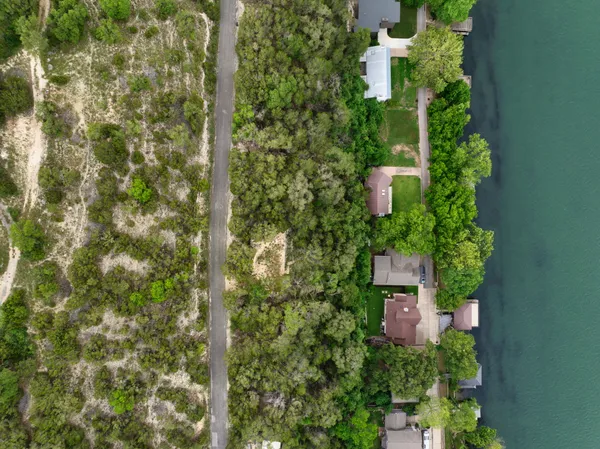 an aerial view of a house with a yard and lake view