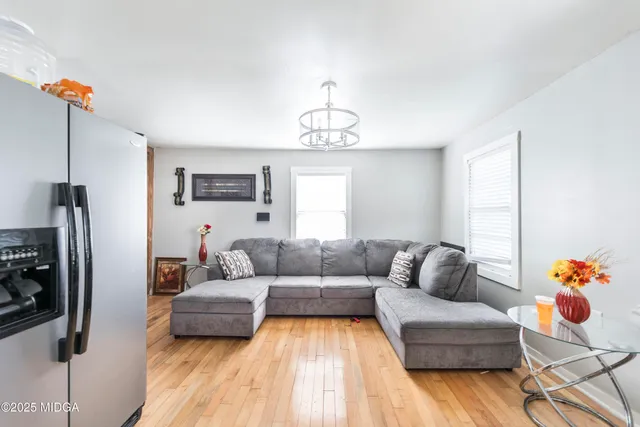 a living room with furniture and a chandelier