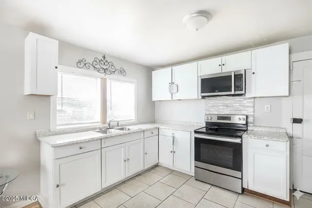 a kitchen with appliances a sink and a window