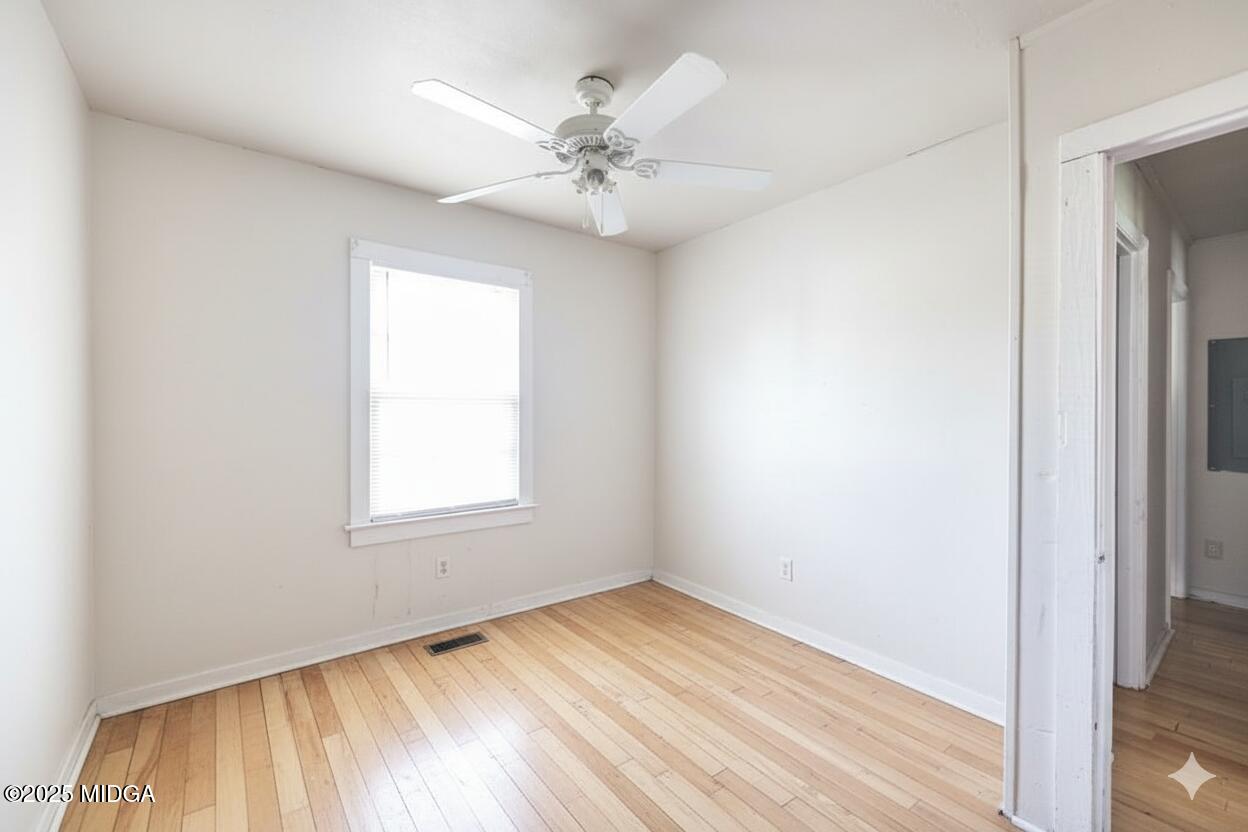 511 Forsyth Street Montezuma, GA 31063 - Photo 10 of 12 an empty room with a window and a ceiling fan