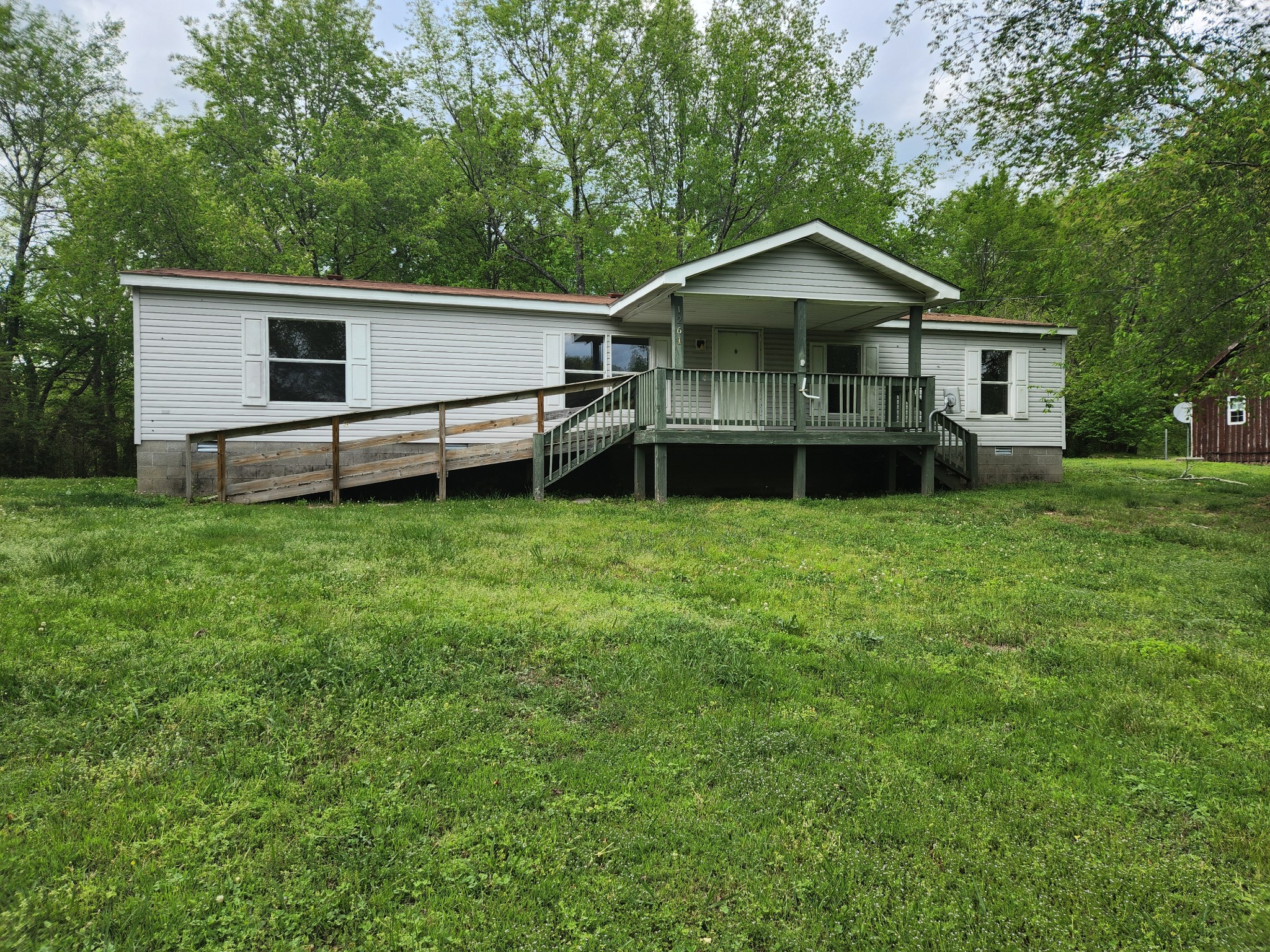 1261 Garton Road Burns, TN 37029 - Photo 3 of 11 a house that has a big yard and large trees