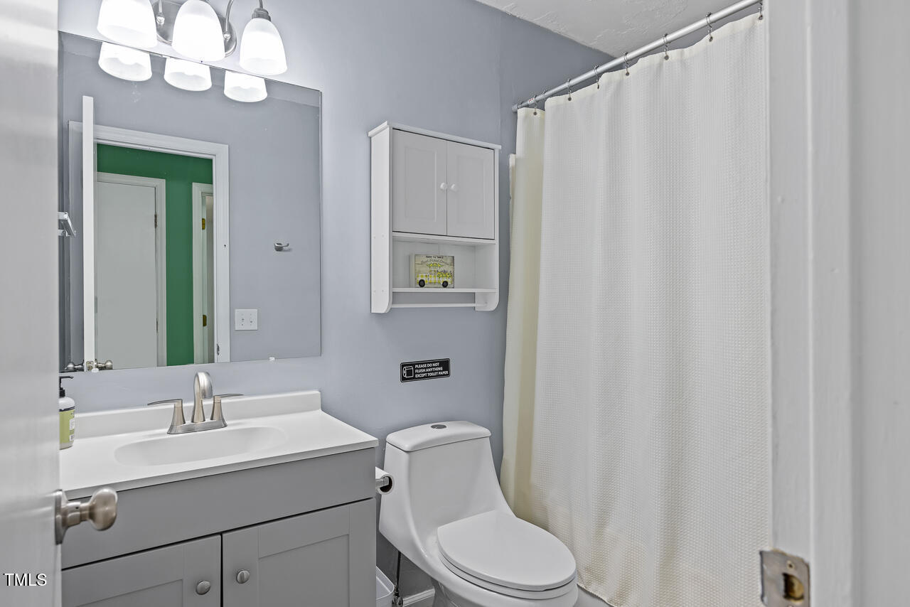 2906 Apollo Street Durham, NC 27704 - Photo 11 of 23 a bathroom with a sink a toilet and shower curtain